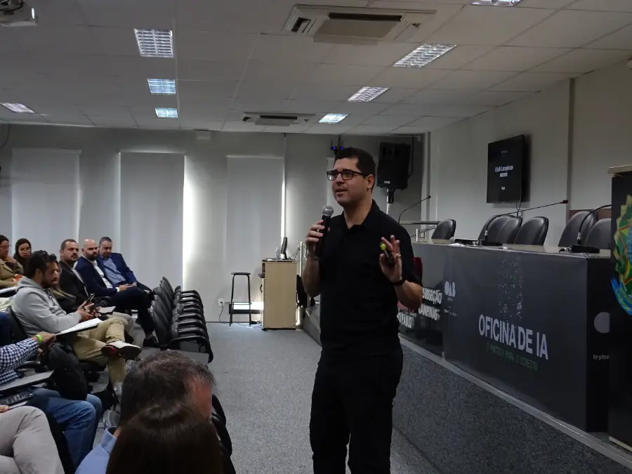 Eli Candido, da Trybe, conduz uma oficina presencial de IA para um auditório